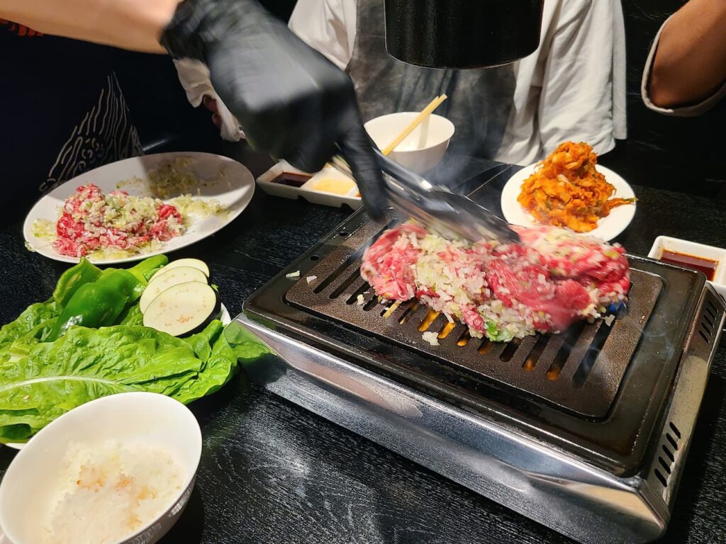 お肉を混ぜて焼く店員さん